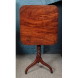 A mahogany tilt top table raised on turned tripod base.