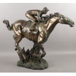 A bronzed figure of a horse with jockey. (50cm height 65cm width)