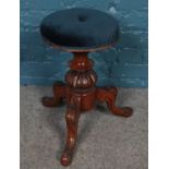 A Victorian carved mahogany adjustable piano stool. With buttoned upholstered seat.