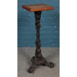 A pine and scrolled cast iron torchiere, on tripod base. Height: 91cm.