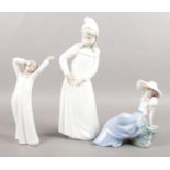Three Nao female figures by Lladro. Two girls in nightgowns and young seated girl with bird.