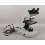 A binocular microscope, by Kyowa (No. 834443), with 4 objectives. Microscope switches on.