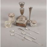 A quantity of silver. Including weighted specimen vase, candlestick, silver lidded jars, silver