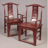 A pair of Chinese horseshoe backed carved hardwood arm chairs, in red lacquer, carved with figures.