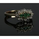 A yellow metal diamond and emerald cluster ring. Size R. 4.32g.