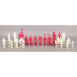 A Chinese carved ivory chess set with puzzle ball stands, natural and stained red. With two