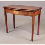 An antique serpentine form mahogany fold over tea table with fan patera motif. Raised on tapering
