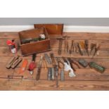 A wooden tool box with various vintage tools. Plyers, hammers, various screwdrivers, Stanley knives,