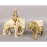 Two Royal Dux figures, one of a man on an elephant, the other of an elephant with a basket. Damage