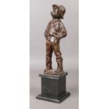 A bronze figure of a young boy raised on a square slate plinth. Modelled smoking a cigar, stood with