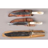 Three bowie knives in leather sheaths. Includes George Wostenholm & Son IXL (blade length 25cm)