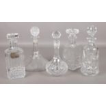 Five cut glass decanters, including one with silver Brandy label.