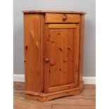 A modern pine corner cabinet, with drawer and hinged door. Height: 90cm, Width: 72cm, Depth: 47cm.