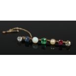 A yellow metal multi stone bar brooch set with two diamonds, a sapphire, an opal, an emerald and a