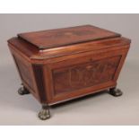 A George IV inlaid mahogany wine cooler of sarcophagus form, raised on four metal lion paw feet.