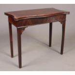 A Georgian mahogany fold over table of serpentine form with crossbanded top and square tapering