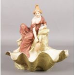 A Royal Dux figure modelled as a girl gathering water from a fountain. 24cm.