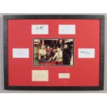 A framed On The Buses autograph display signed by six of the main cast. 48cm x 66cm.