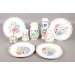 Nine pieces of Poole pottery. To include four dinner plates, jug and vases with off white ground and