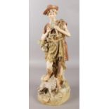 An early 20th century large Royal Dux figure of a shepherd boy playing pipes with a dog at his feet.