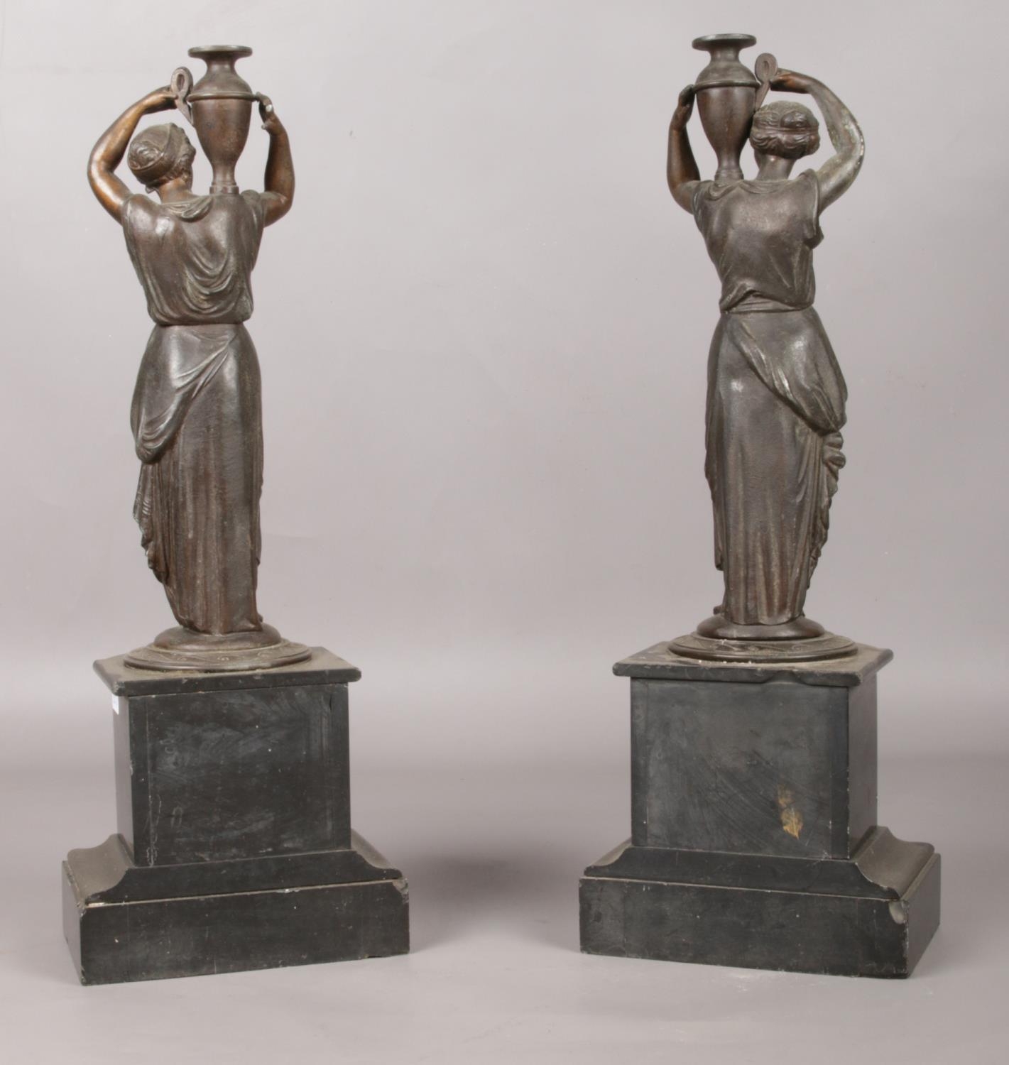 A pair of bronze figures raised on marble plinths modelled as water carriers. 41.5cm. - Image 3 of 3