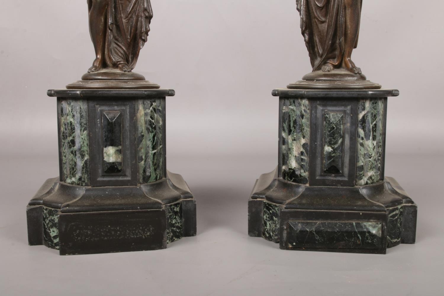 A pair of bronze figures raised on marble plinths modelled as water carriers. 41.5cm. - Image 2 of 3