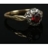 An 18ct Gold ring, set with large central red stone surrounded by small diamonds. Size M½. Total