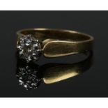 An 18ct gold diamond solitaire ring. The diamond illusion set, approximately 1/8ct. Size P. 3.9g.