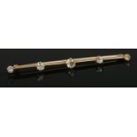 A large yellow metal and moissanite bar brooch. 7.5cm long.