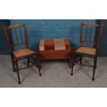 A pair of mahogany and bergere chairs, together with a teak piano stool with hinged top.