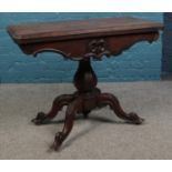 A Victorian rosewood fold over card table, with red baize insert and carved cabriole feet, raised on