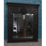A Victorian bevel edged mirrored panel, with carved foliate surround and central thistle crest.