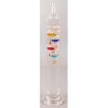 A glass Galileo thermometer. Height 28cm.