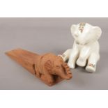 A Lenox porcelain figure of an elephant, along with a carved wooden elephant doorstop.