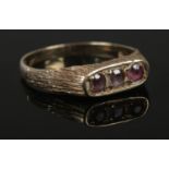 A 9ct Gold ring with solid raised bridge, set with 3 pink stones. Size P. Total weight: 1.71g.