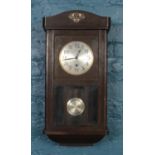 A carved mahogany wall clock with silvered dial.