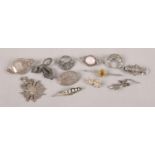 A collection of twelve silver brooches and pendants. To include marcasite example formed as a lizard