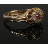 An 18ct Gold halo cluster ring, set with central pink stone surrounded by 12 small diamonds.