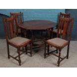 An oak drop leaf gate leg table, together with four oak dining chairs with fabric upholstered