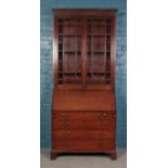 A Georgian bureau bookcase, with fold down top revealing fitted interior. Height: 244cm, Width: