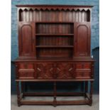 A carved dark oak dresser, with marquetry star motif to upper cupboard doors. Height: 198cm,