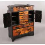 A decorative Japanese lacquered and inlaid cabinet. Height 39.5cm.