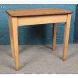 A small pine kitchen table/desk, with painted legs. Height: 82cm, Width: 91cm, Depth: 54cm.