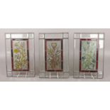 A trio of modern stained glass panels, with red borders depicting fruit and foliage (31cm x 20cm).