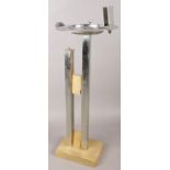 An Art Deco metal smokers stand with attached matchbox holder and ashtray.
