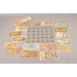 A collection of foreign bank notes and three pence pieces dating from 1942. Notes to include