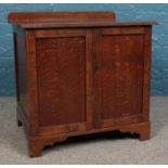 A lockable mahogany sewing cabinet with hinged doors revealing baize lined drawers. Height: 63cm,