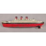 A Tin plate wind-up model of the RMS Queen Mary. L: 34cm. No key to wind-up. Play worn.