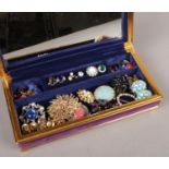 A purple velvet jewellery box with contents of costume jewellery. Includes vintage dress rings,