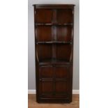 An Ercol Old Colonial corner cupboard with open top and cupboard base.